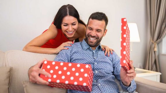 Mujer dando un regalo a un hombre en una caja sorpresa.