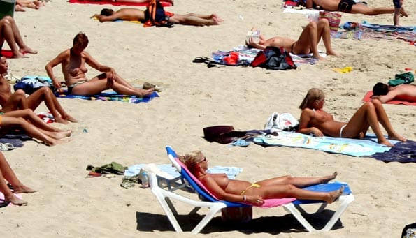 Jóvenes hacen topless para ponerse morenas.