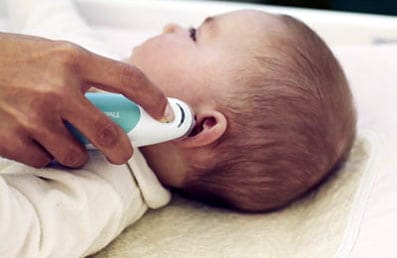 Comprueban con un termómetro si un bebé tiene fiebre.