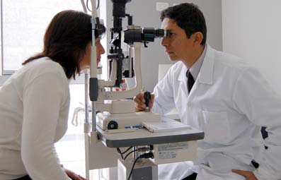 Oftalmólogo hace una prueba ocular a una paciente.