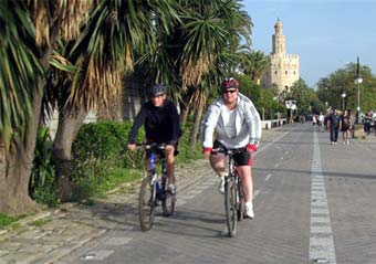 Dos ciclistas pasean en bici por Sevilla.