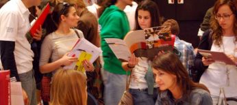 Estudiantes universitarios en una feria para elegir formación superior como Másters.