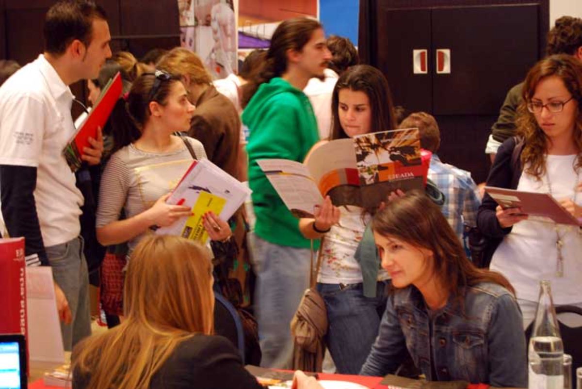 Estudiantes universitarios en una feria para elegir formación superior como Másters.