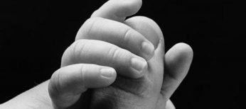Mano de un niño agarrando el dedo de su padre.