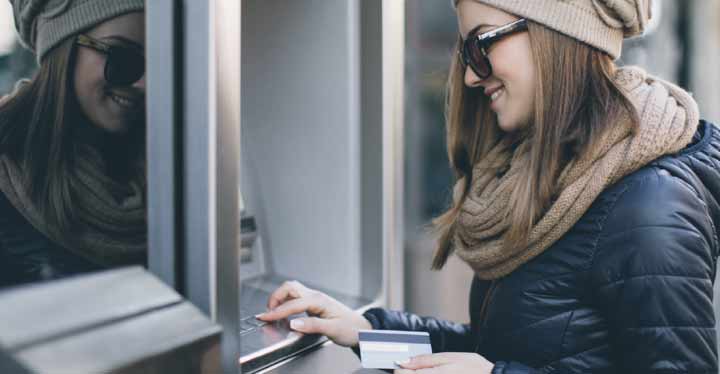 Persona joven sacando dinero del cajero
