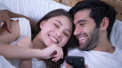 Una pareja abrazada en la cama.