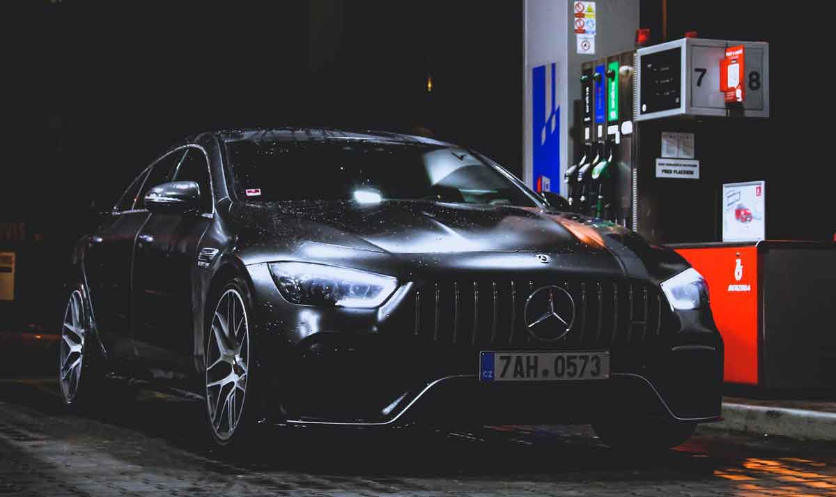 Coche con las luces encendidas en una gasolinera.