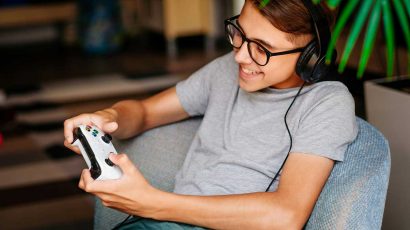 Un niño adolescente jugando a la videoconsola con unos cascos gaming.
