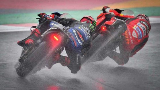 Moto Yamaha y Ducati tomando una curva en lluvia.