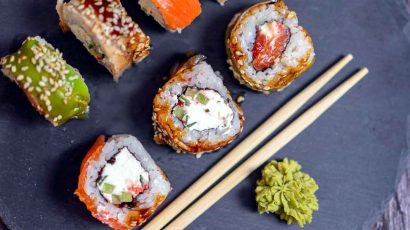 Sushi y wasabi con palillos chinos.