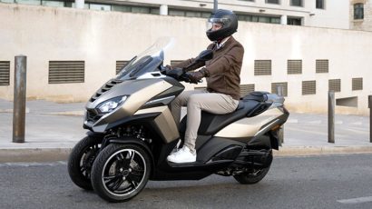 Persona conduciendo una moto de tres ruedas por la ciudad.
