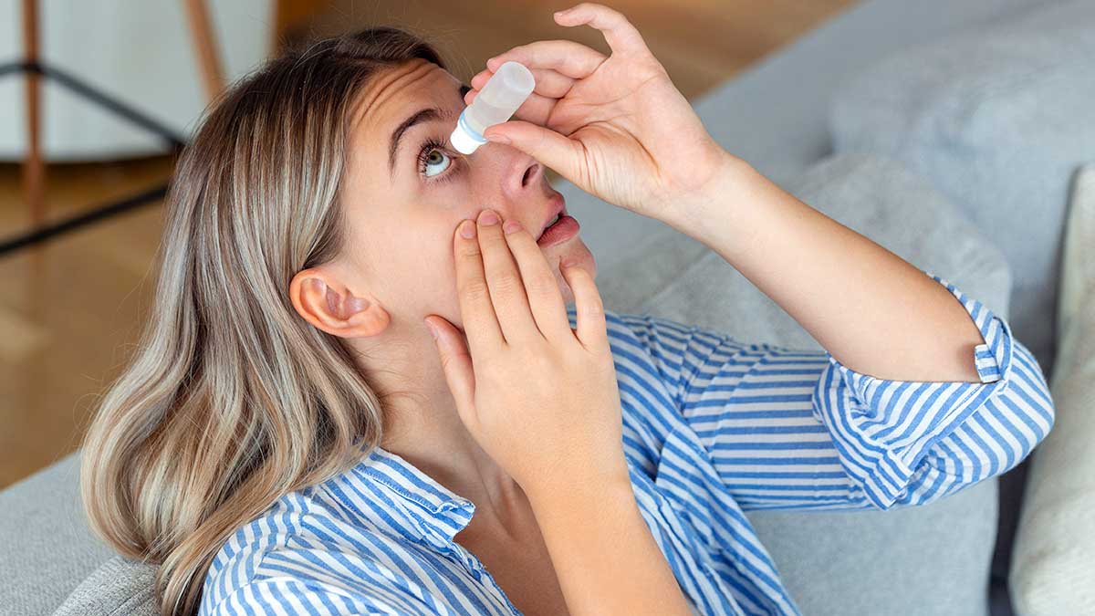 Mujer echándose gotas de colirio para los ojos.