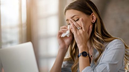 Mujer con un pañuelo y frotándose los ojos.