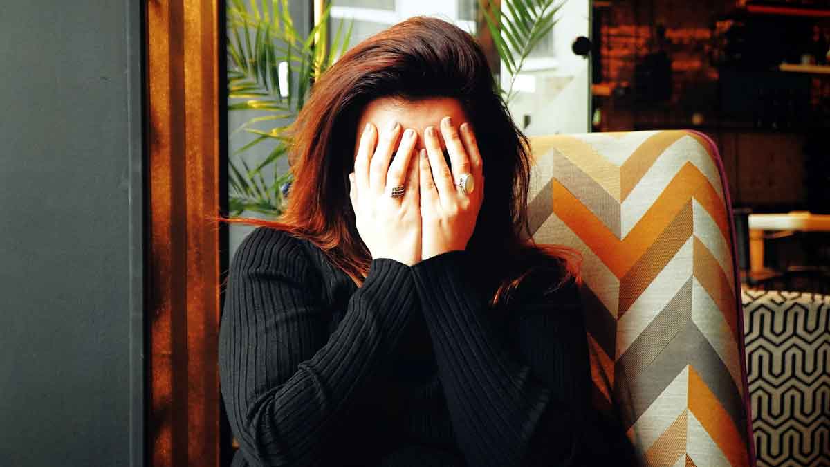 Chica tímida con las manos en la cara.