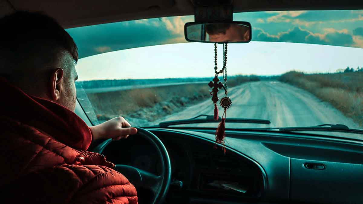 Rosario colgado del retrovisor del coche