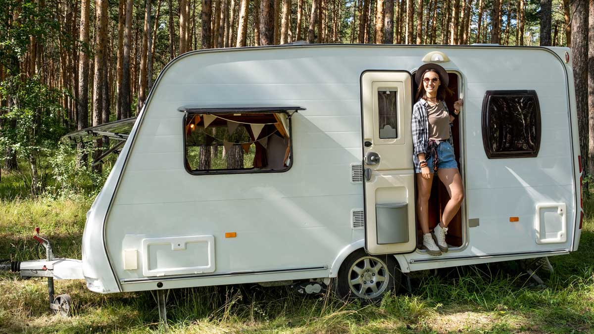 Chica dentro de una caravana en el campo.