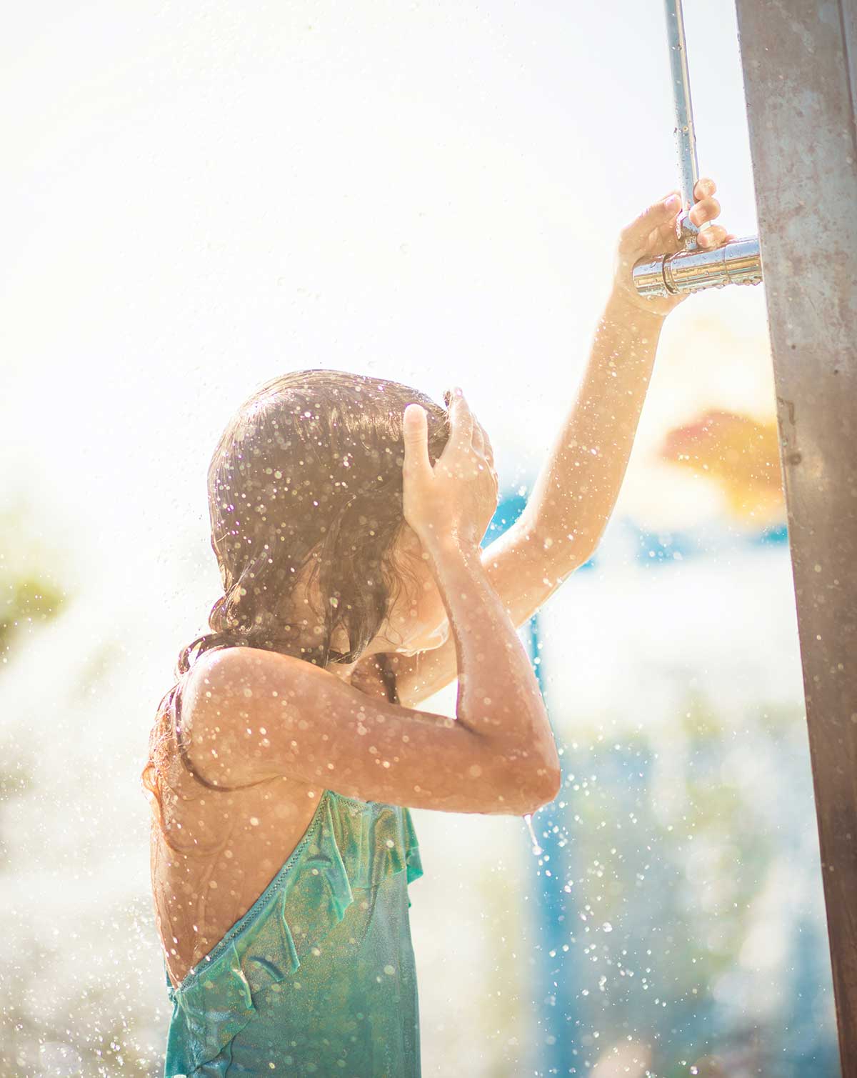 Girl takes a bath in the pool shower.
