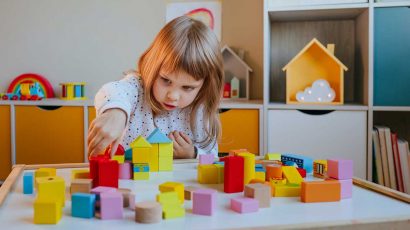 Niña jugando con unos bloques de construcción.