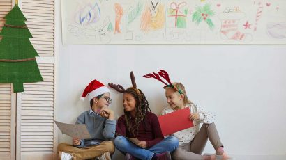 Tres niños en el colegio disfrazados con motivos navideños.