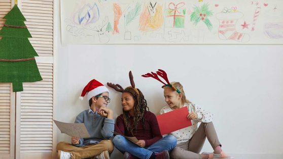 Tres niños en el colegio disfrazados con motivos navideños.