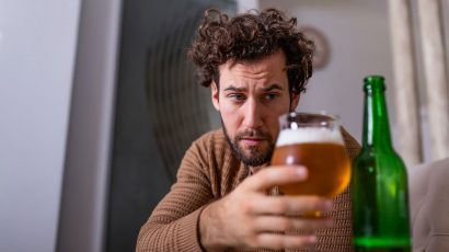 Una persona en estado de embriaguez tomando una cerveza.