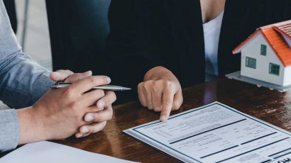 Dos personas firmando los términos de un contrato.