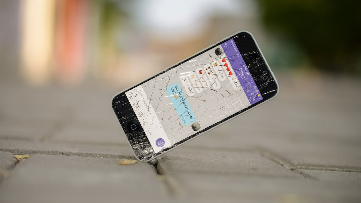 Móvil en el suelo con la pantalla rota