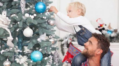 Padre e hijo montando el árbol de Navidad.