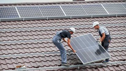 Trabajadores instalan placas solares en el tejado de una vivienda.