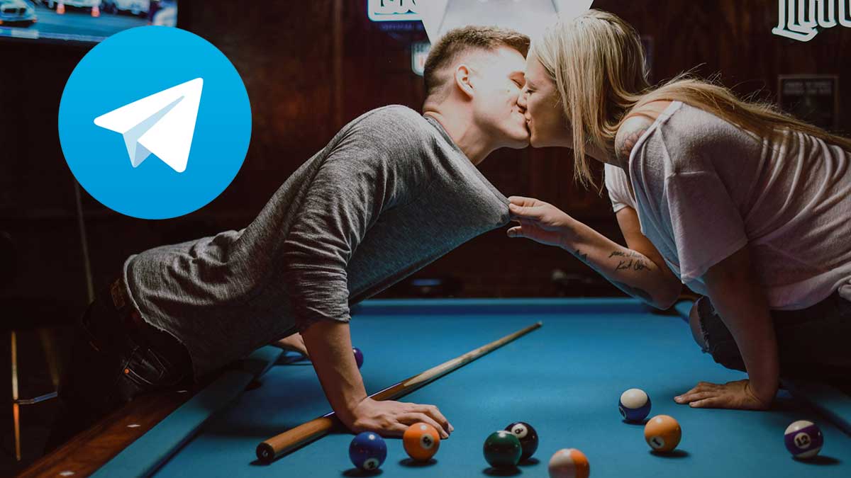 Una pareja besándose mientras juega al billar.