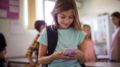 Niña con móvil en clase