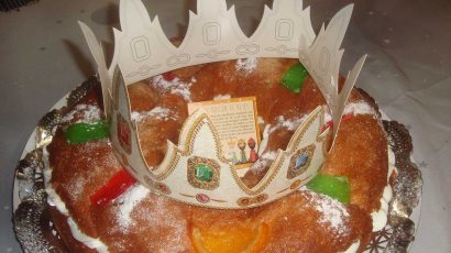 Tradicional Roscón de Reyes relleno de nata con una corona.