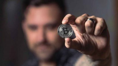 Una persona sosteniendo un Bitcoin.