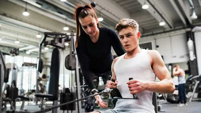 Una persona haciendo ejercicio en el gimnasio con ayuda de una monitora.