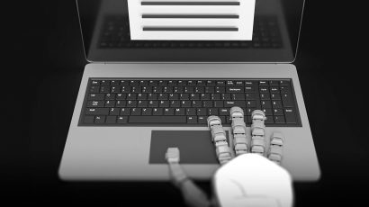 Una mano de un robot escribiendo en el teclado de un ordenador portátil.