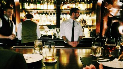 Un camarero trabajando en la barra de un bar de copas.