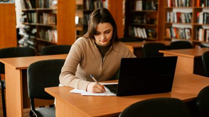 Una chica estudiando en la biblioteca.