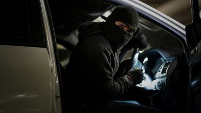 Un ladrón dentro del coche robándolo.