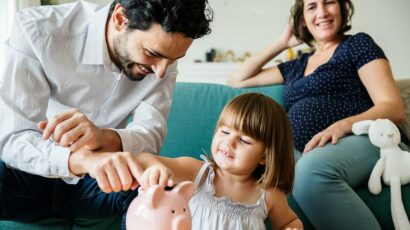 Una niña con sus primeros ahorros en su hucha.