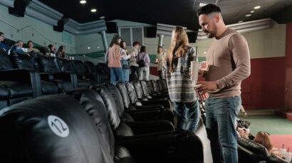 Un espectador con comida antes de empezar la película en la sala de cine.