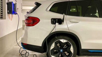 Coche eléctrico cargándose en un parking.