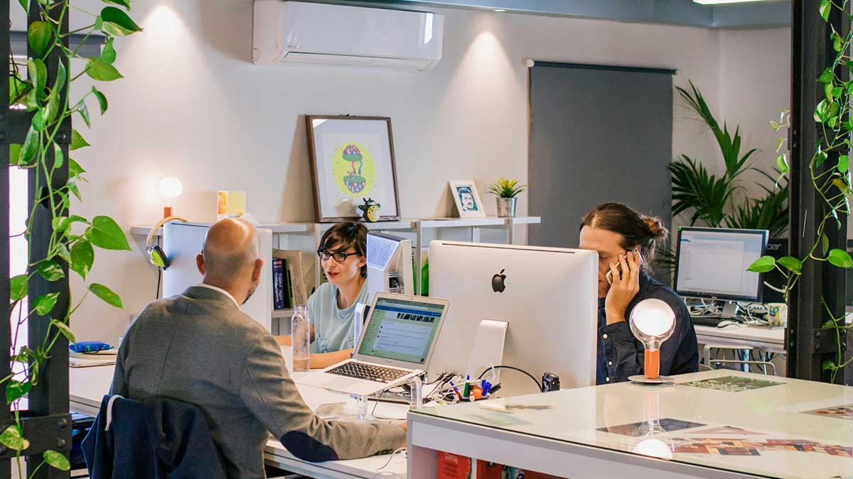 Unos trabajadores durante su jornada laboral en sus puestos de trabajo.