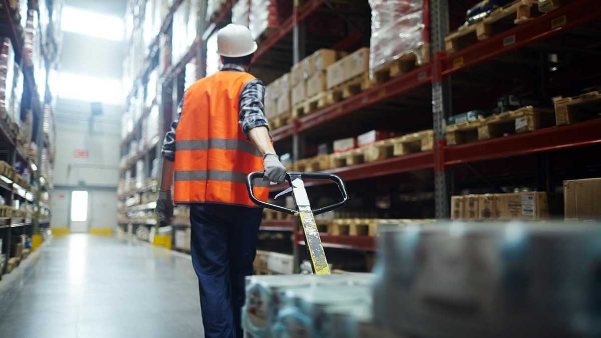 Un operario de logística con una carretilla manual.