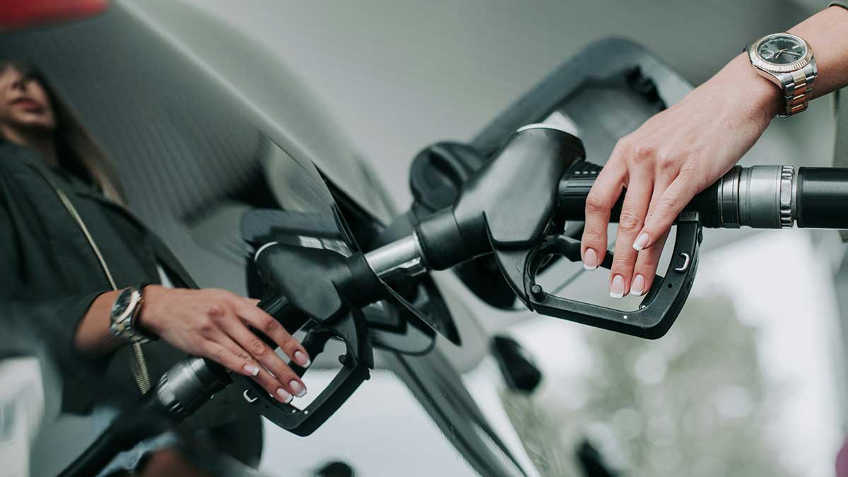 Una mujer llena el tanque de su coche en una gasolinera.
