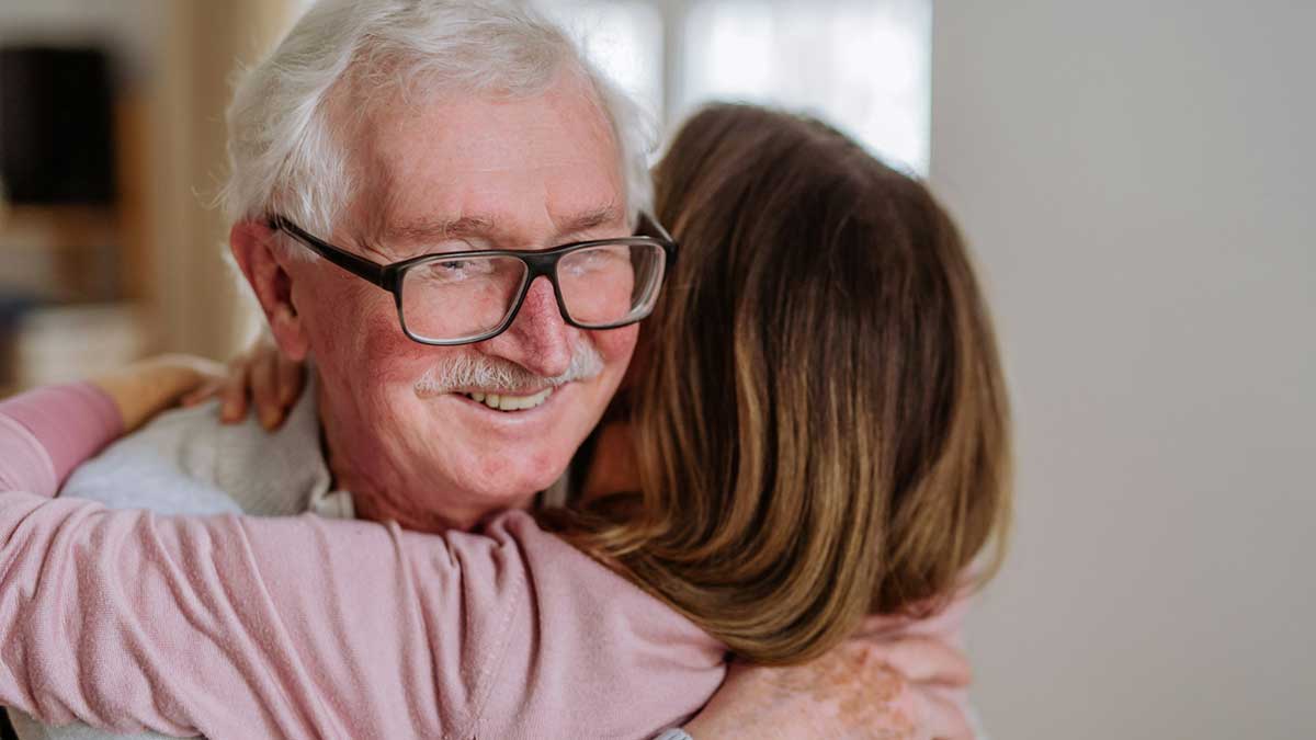 Una pareja de jubilados se abraza.