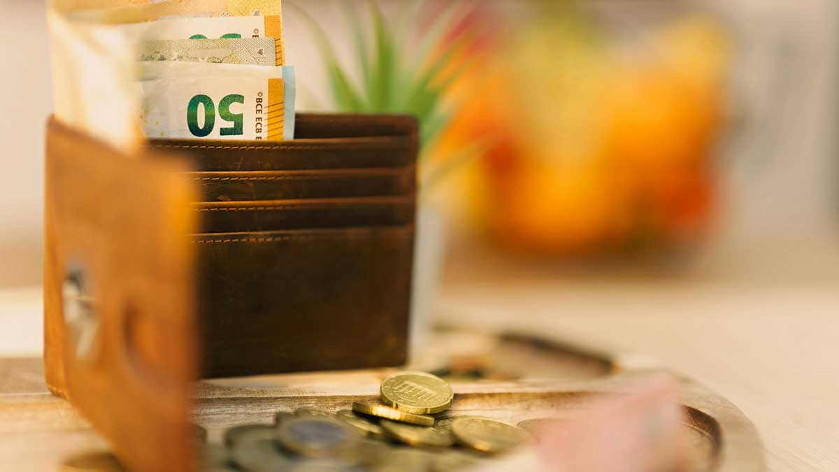 Una cartera con billetes sobre una mesa.